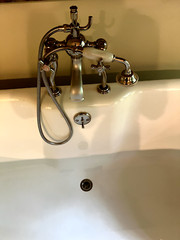66” Porcher cast iron bathtub with clawfoot legs and polished chrome fixtures